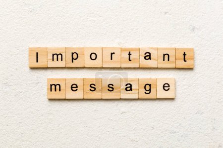 Mensaje importante palabra escrita en bloque de madera. Texto de mensaje importante en la mesa de cemento para su diseño, concepto de vista superior.