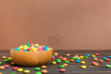 Caramelos multicolores en un bol sobre un fondo de color. concepto de cumpleaños y vacaciones. Vista superior con espacio de copia.