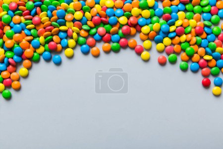 Foto de Colección mixta de dulces de colores, sobre fondo de colores. Asiento plano, vista superior. marco de caramelo recubierto de chocolate colorido. - Imagen libre de derechos