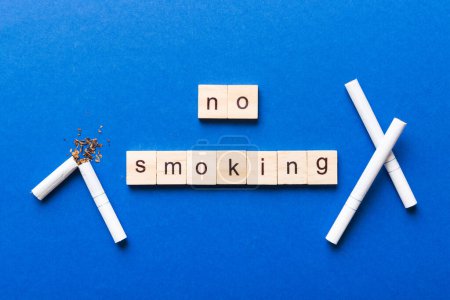 Zigaretten- und Holzklötze, kaputte Zigarette auf Tischhintergrund, No Tobacco Day mit Sanduhr, Uhr Gesundheitskonzept. Zeit, mit dem Rauchen aufzuhören.