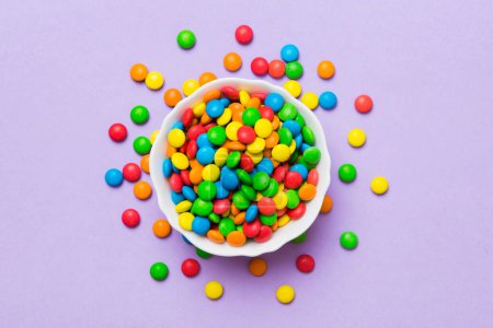 Photo for Multicolored candies in a bowl on a colored background. birthday and holiday concept. Top view with copy space. - Royalty Free Image