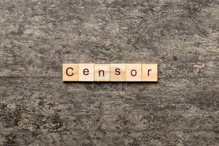 Foto de Palabra censuradora escrita en bloque de madera. Censor de texto en la mesa de cemento para su diseño, concepto. - Imagen libre de derechos