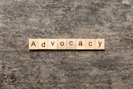 Photo for ADVOCACY word written on wood block. ADVOCACY text on cement table for your desing, concept. - Royalty Free Image