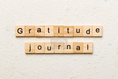 Gratitude Journal word written on wood block. Gratitude Journal text on cement table for your desing, concept.