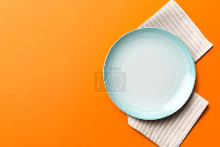 Photo for Top view on colored background empty round Blue plate on tablecloth for food. Empty dish on napkin with space for your design. - Royalty Free Image