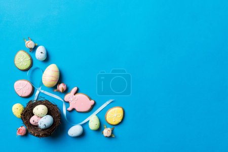Foto de Huevos coloridos de Pascua en el nido en el fondo de la mesa con vista superior espacio de copia. - Imagen libre de derechos