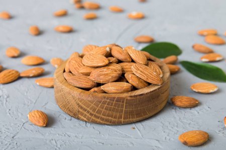 Téléchargez les photos : Fresh healthy Almond in bowl on colored table background. Top view. - en image libre de droit