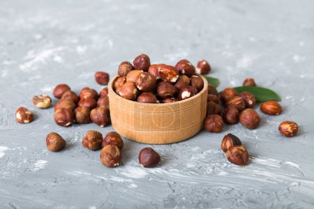 Foto de Wooden bowl full of hazelnuts on table background. Healthy eating concept. Super foods. - Imagen libre de derechos