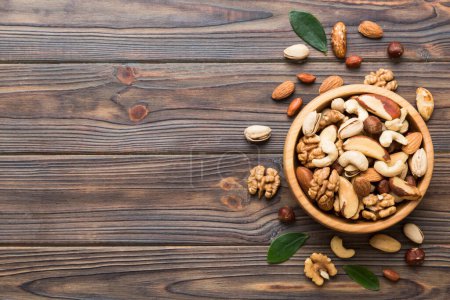 Foto de Mixed nuts in bowl. Mix of various nuts on colored background. pistachios, cashews, walnuts, hazelnuts, peanuts and brazil nuts. - Imagen libre de derechos