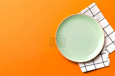 Photo for Top view on colored background empty round green plate on tablecloth for food. Empty dish on napkin with space for your design. - Royalty Free Image