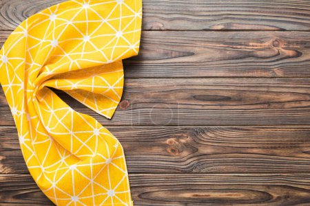 Photo for Top view with yellow empty kitchen napkin isolated on table background. Folded cloth for mockup with copy space, Flat lay. Minimal style. - Royalty Free Image