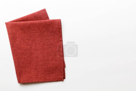 Photo for Top view with red empty kitchen napkin isolated on table background. Folded cloth for mockup with copy space, Flat lay. Minimal style. - Royalty Free Image