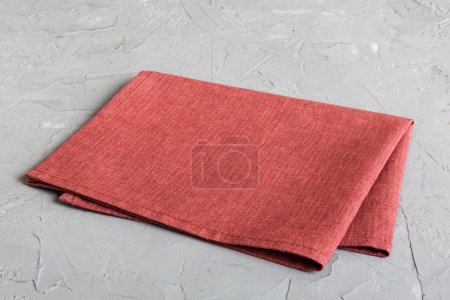 Téléchargez les photos : Top view with red empty kitchen napkin isolated on table background. Folded cloth for mockup with copy space, Flat lay. Minimal style. - en image libre de droit