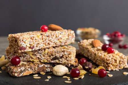 Photo for Various granola bars on table background. Cereal granola bars. Superfood breakfast bars with oats, nuts and berries, close up. Superfood concept. - Royalty Free Image