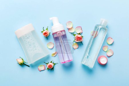 Schicke Gesundheitsflaschen für Serum, Mikrokeller, Tonikum, Toner, Lotion, Wasser und Sahne mit Rosenblüte. Natürliche oranische Kurkosmetik-Konzept. Attrappe, Vorlage, Draufsicht.