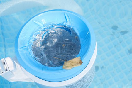 Vista superior del skimmer azul para limpiar la piscina en agua clara. Concepto de limpieza de piscinas contaminadas.