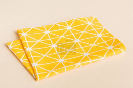 Photo for Top view with yellow empty kitchen napkin isolated on table background. Folded cloth for mockup with copy space, Flat lay. Minimal style. - Royalty Free Image