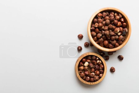 Foto de Wooden bowl full of hazelnuts on table background. Healthy eating concept. Super foods. - Imagen libre de derechos