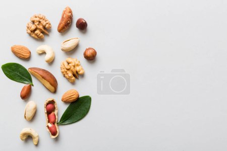 Foto de Composition of nuts , flat lay - mix hazelnuts, cashews, almonds on table background. healthy eating concepts and food background. - Imagen libre de derechos