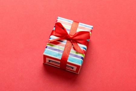 Photo for Wrapped christmas or other holiday handmade present in paper with colored ribbon. Present box, decoration of gift on table, top view with copy space. - Royalty Free Image