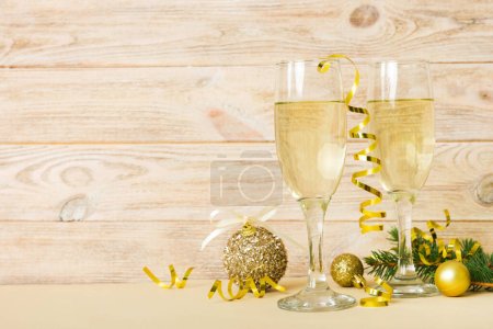 Photo for Champagne glasses and christmas decor on colored holiday background. Flat lay New Year decorations. - Royalty Free Image