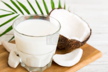 Photo for Coconut products on white wooden table background. Dairy free milk substitute drink, Flat lay healthy eating. - Royalty Free Image