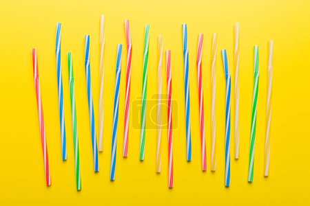 Photo for Many multi-colored plastic tubes for cocktail on Colored background, top view. - Royalty Free Image