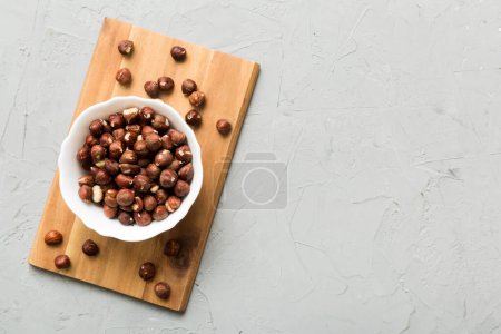 Foto de Cuenco de madera lleno de avellanas sobre fondo de mesa. Concepto de alimentación saludable. Súper alimentos. - Imagen libre de derechos