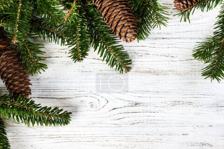 Foto de Ramas de árbol de Navidad con conos sobre un fondo de madera
. - Imagen libre de derechos