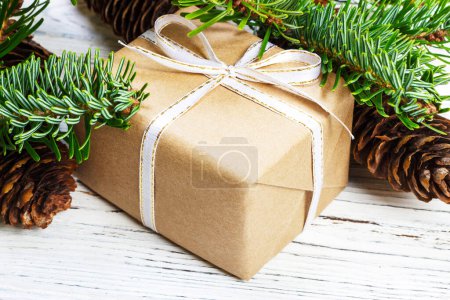 Photo for Christmas gift box on the white wooden table background,spruce branch,pine cones,frame,top view, space for text. - Royalty Free Image