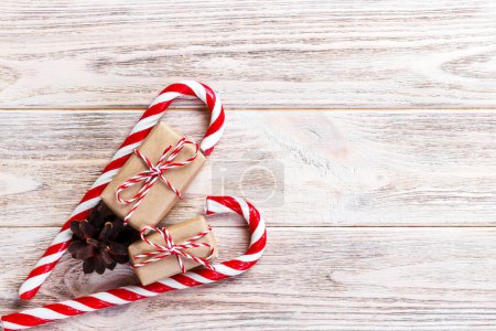 Photo for Candy canes and christmas gift on brown wooden background. - Royalty Free Image