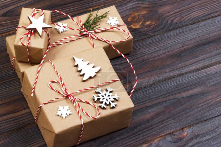 Weihnachtsgeschenkbox dekoriert mit Schneeflocke auf Holzhintergrund.