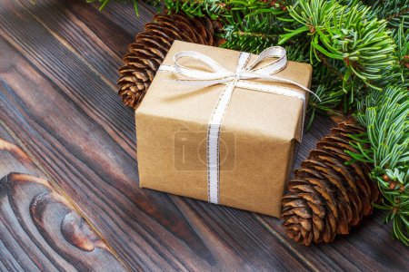 Téléchargez les photos : Composition de Noël. Cadeau de Noël, couverture tricotée, cônes de pin, branches de sapin sur fond blanc en bois. Couché plat, vue du dessus
. - en image libre de droit