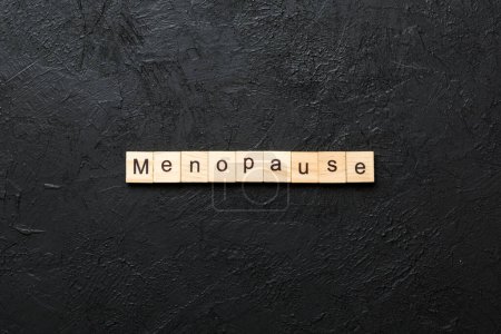 menopause word written on wood block. menopause text on table, concept.