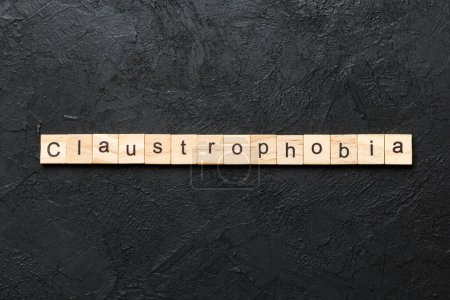 claustrophobia word written on wood block. claustrophobia text on table, concept.