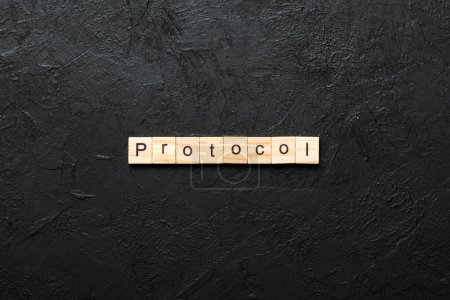 PROTOCOL word written on wood block. PROTOCOL text on cement table for your desing, concept.