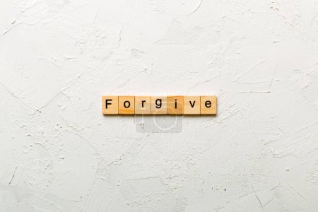 Forgive word written on wood block. Forgive text on cement table for your desing, Top view concept.