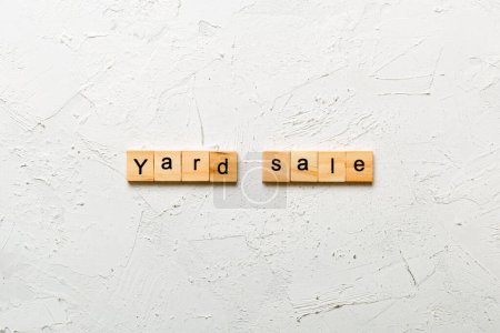 Palabra de venta de patio escrita en bloque de madera. Yard texto de venta en la mesa de cemento para su diseño, concepto de vista superior.