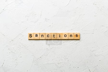 sanction word written on wood block. sanction text on table, concept.