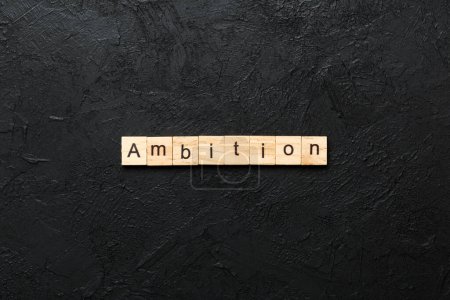 palabra de ambición escrita en madera. texto de ambición en la mesa de cemento para su diseño, concepto.