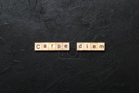 Carpe diem word written on wood block. Carpe diem text on table, concept.