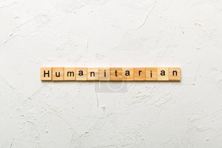 humanitäre Wort auf Holzklotz geschrieben. Humanitärer Text auf dem Tisch, Konzept.