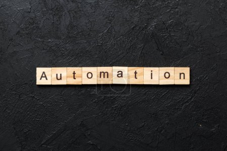 Palabra de automatización escrita en bloque de madera. Texto de automatización en la mesa de cemento para su diseño, concepto
.
