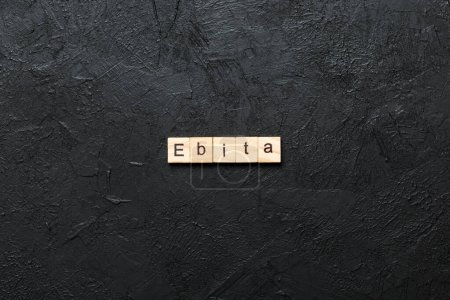 Palabra EBITA escrita en madera. EBITA texto sobre mesa de cemento para su diseño, concepto.