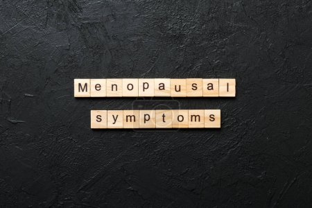 menopausal symptoms word written on wood block. menopausal symptoms text on cement table for your desing, concept.