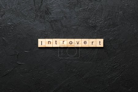 Introvertiertes Wort auf Holzblock geschrieben. Introvertierter Text auf Tisch, Konzept.
