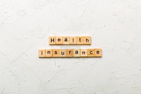 Health insurance word written on wood block. Health insurance text on cement table for your desing, concept.