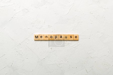 mot de ménopause écrit sur un bloc de bois. texte de la ménopause sur la table, concept.