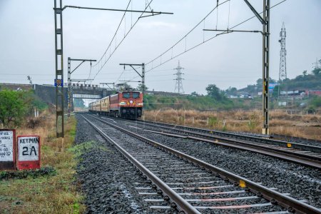 Photo for Khandala, India - May 07 2023: Passenger train hauled by a WAP4 Electric locomotive at Kamshet near Pune India. - Royalty Free Image