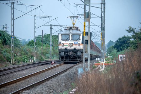 Photo for Pune, India - July 09 2023: Passenger train hauled by a WAP7 electric locomotive near Pune India. - Royalty Free Image